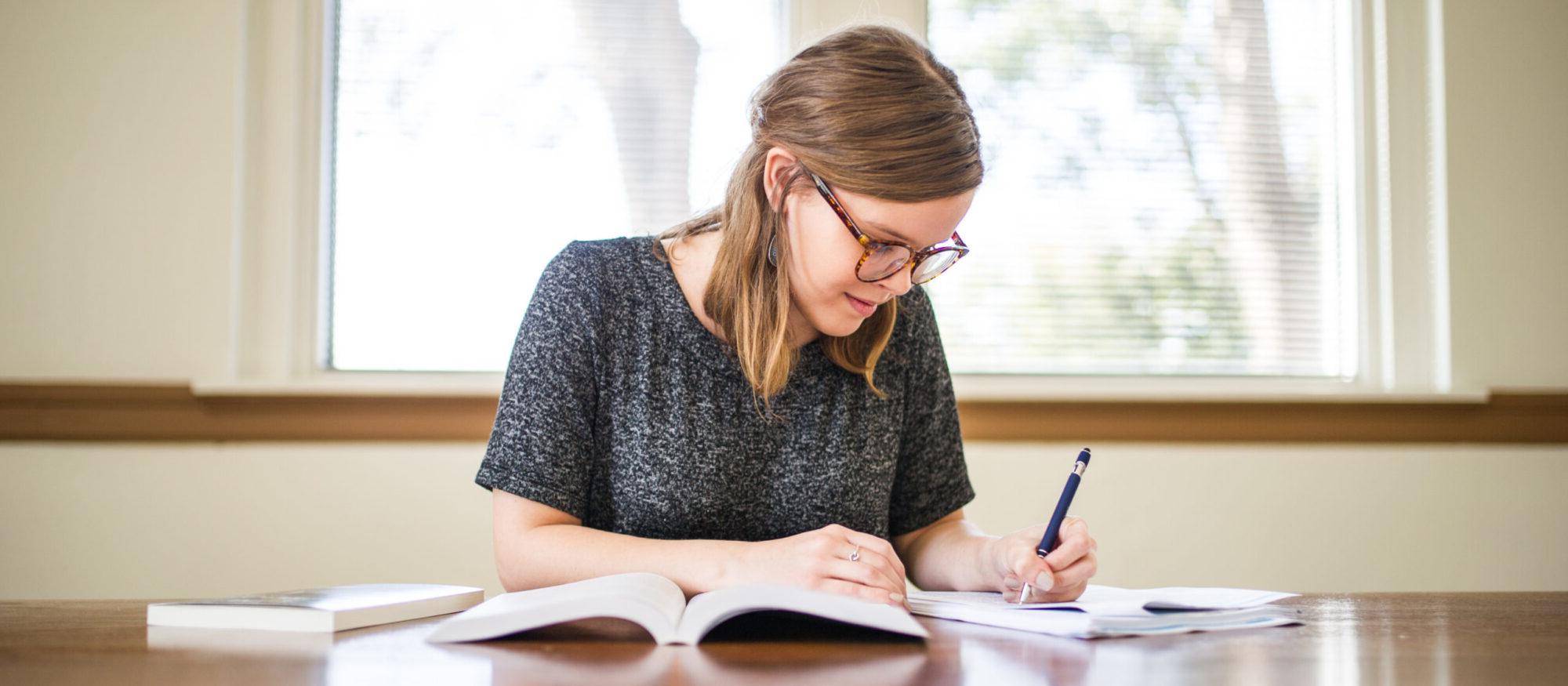 Woman writing at a table. 