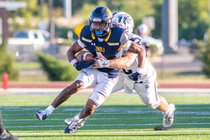 A male football player tackling another male football player.