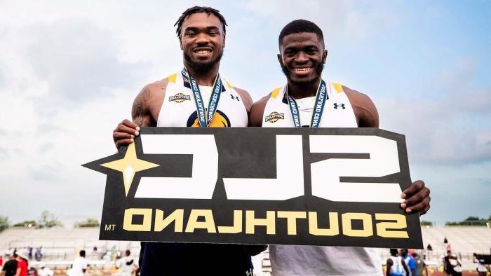 Two athletes hold "SLC Southland" sign.